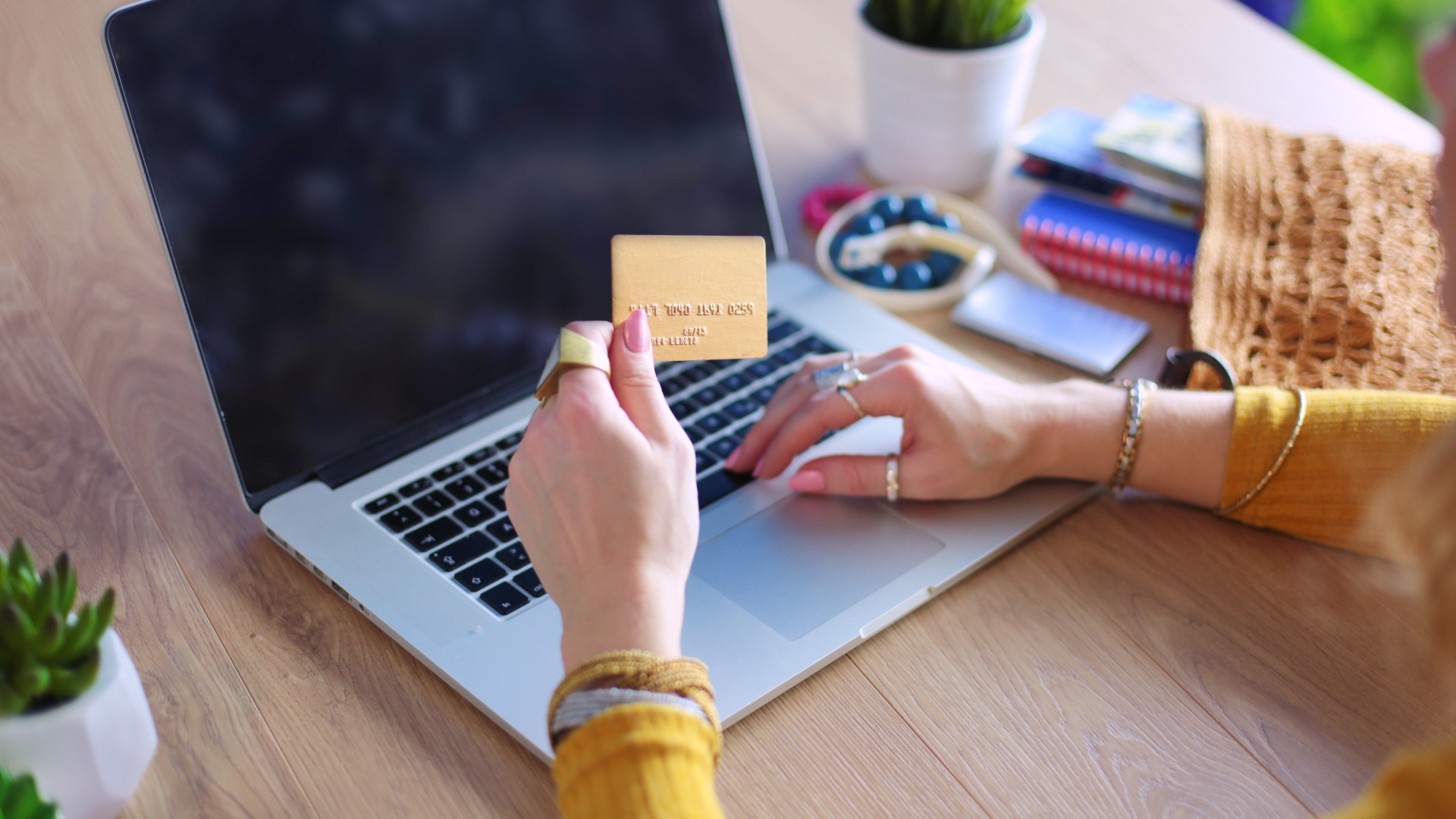woman-holding-credit-card woman holding a credit card in front of a laptop